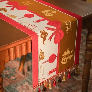 Dettaglio del runner da tavola jacquard etnico con carattere Fu e nappe colorate