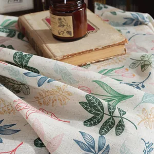 Detail of linen tablecloth with colorful hand-painted leaf prints and rustic texture