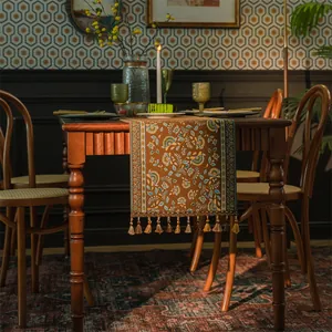 Dettaglio del runner da tavola boho vintage con motivi floreali jacquard e nappe eleganti