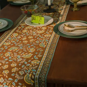 Dettaglio del runner da tavola vintage con motivi floreali jacquard e frange blu