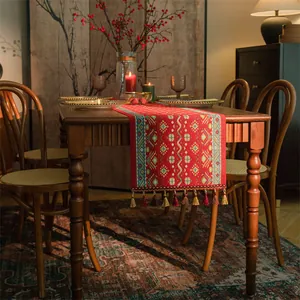 Dettaglio del runner da tavola etnico rosso con motivi jacquard e frange colorate