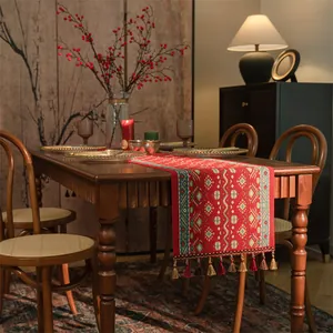 Dettaglio di runner da tavola jacquard rosso con motivi etnici e frange di nappe