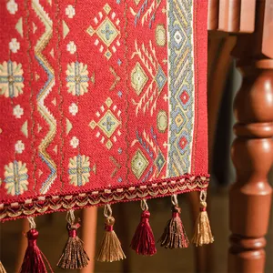 Dettaglio di runner da tavola jacquard rosso bohémien con motivi geometrici e frange
