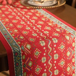 Dettaglio dei motivi jacquard geometrici su un runner da tavola bohémien rosso