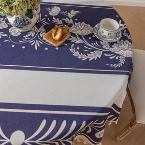 Détail de la nappe ronde à motifs floraux avec pompons et texture en mélange de coton et lin