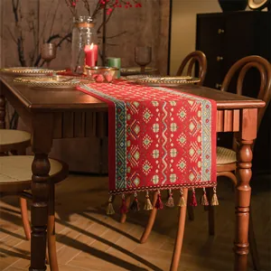 Dettaglio runner da tavola etnico rosso con ricamo jacquard e frange intrecciate colorate