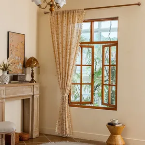 Detail of floral semi-sheer linen curtain with decorative fringe tassels and vintage style
