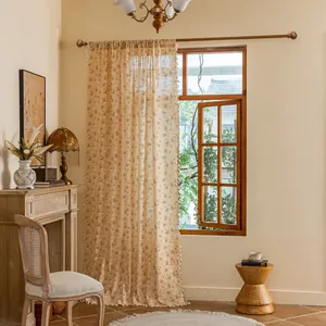 Detail of floral curtain with small tassels and semi-sheer linen fabric in sunlight