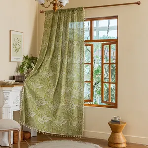 Detail of green leaf print curtain featuring elegant white tassels and semi-sheer fabric