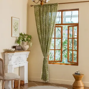Detail of green forest curtains with white leaf prints and fringe trim for home decor