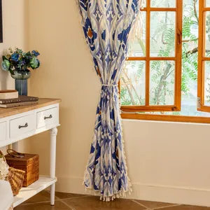 Detail of vintage geometric ikat curtain with white tassel fringe and matching tie-back