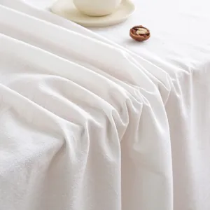 Close-up of white linen tablecloth with natural texture and elegant minimalist setting