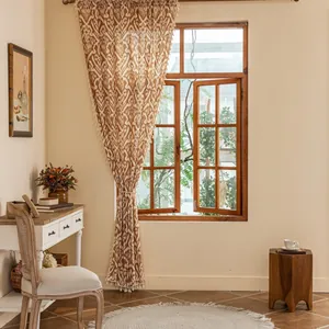 Detail of warm orange bohemian curtain with geometric patterns and tassel fringe trim