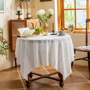 White cotton tablecloth with embroidered stripes and hollow lace edge in French country style