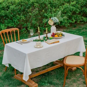 Minimalistisch wit katoenen tafelkleed met textuur op een houten tafel in zonlicht