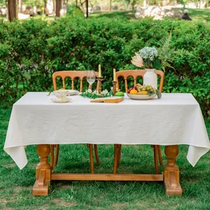 Detail van een beige outdoor tafelkleed met natuurlijke kreukeltextuur op een tuintafel