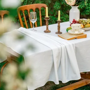 Detailopname van elegant wit stoffen tafelkleed met natuurlijke textuur op hout