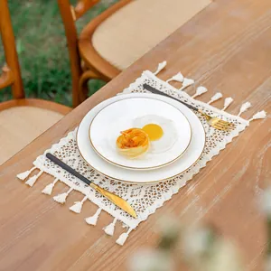 Set de table bohème en coton beige avec franges disposé sur une table en bois rustique