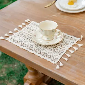 Chemin de table bohème en dentelle au crochet avec franges sur une table en bois rustique