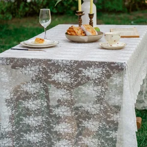Elegant white lace tablecloth with floral embroidery and scalloped edges for wedding decor