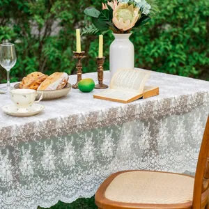 White floral lace tablecloth with elegant embroidery and wavy edges for wedding decor