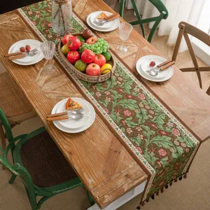 Macro-opname van retro bloemen jacquard tafelloper met franjes op houten tafel