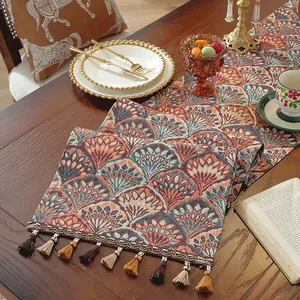 Dettaglio di runner da tavola jacquard bohémien con motivi a ventaglio e frange a nappa