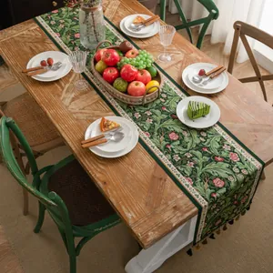Detail van donkergroene jacquard tafelloper met kwastjes en vintage bloemenpatronen