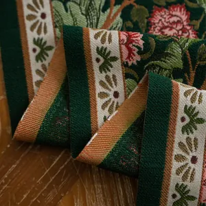 Detail van vintage jacquard tafelloper met groene bloemmotieven op houten ondergrond