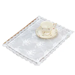 Set de table vintage en dentelle blanche avec broderies florales sur fond en bois