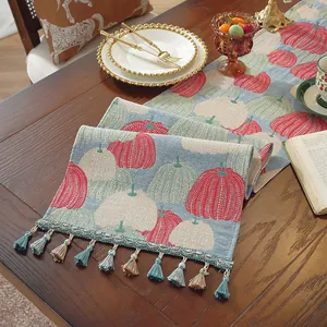 Dettaglio del runner da tavola jacquard con motivo a zucca e nappine decorative