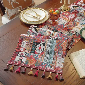 Dettaglio del runner da tavola jacquard bohémien con motivi geometrici e nappe colorate