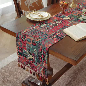 Dettaglio del runner da tavola bohémien con motivi etnici e nappe colorate eleganti
