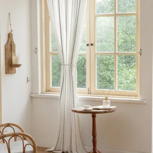 Detail of white striped curtain fabric with grey embroidery and fringe tassels