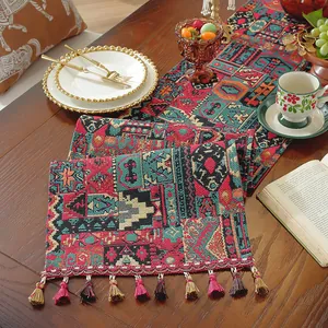 Dettaglio di runner da tavola boho con trama complessa e nappe colorate