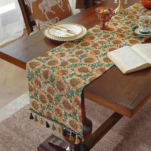 Dettaglio runner da tavolo jacquard girasole con nappe decorative su tavolo in legno