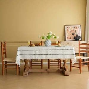 Detail van een crème boho tafelkleed met zwarte weving en franjes aan de rand