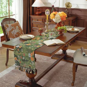 Dettaglio del runner da tavolo boho verde scuro con motivi floreali e nappe di lusso