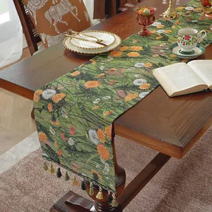 Dettaglio del runner da tavola jacquard con motivi floreali e frange colorate sui bordi