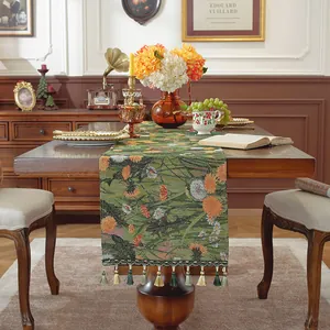 Dettaglio del runner da tavolo jacquard verde con motivi a margherita e nappe a frangia
