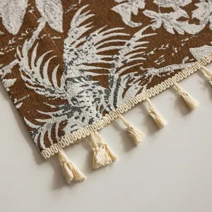 Detalle de cortina bohemia con estampado de hojas y bordes de flecos en color beige