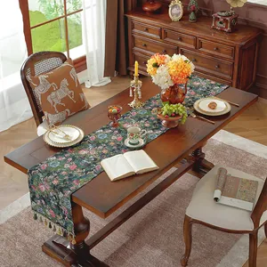 Dettaglio del runner da tavola jacquard floreale verde scuro con nappine colorate