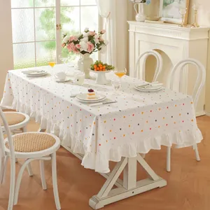 Détail d'une nappe en coton blanc à pois colorés avec bordure à volants pour la décoration