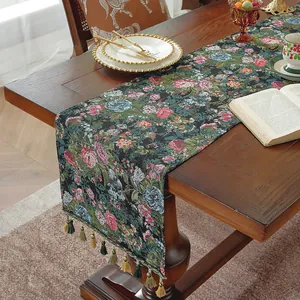 Dettaglio runner da tavola jacquard floreale con frange decorative su tavolo in legno