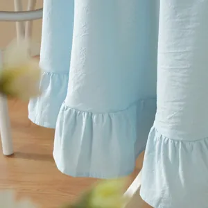 Detail of light blue tablecloth with cotton linen texture and ruffle hem on floor