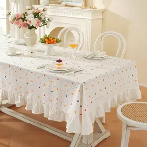 Nappe à pois avec bordure à volants sur une table rectangulaire dans une salle à manger