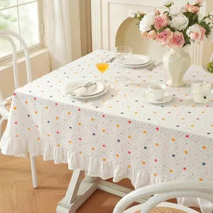 Détail de la nappe blanche à pois colorés et bords à volants élégants et festonnés