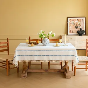 Detail van marineblauwe strepen en decoratieve kwastjes op het beige minimalistische tafelkleed