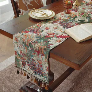 Dettaglio del runner da tavolo jacquard verde con motivo floreale e nappe decorative