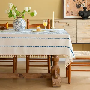 Detail van modern jacquard tafelkleed met blauwe patronen en fijne franjes aan de rand
